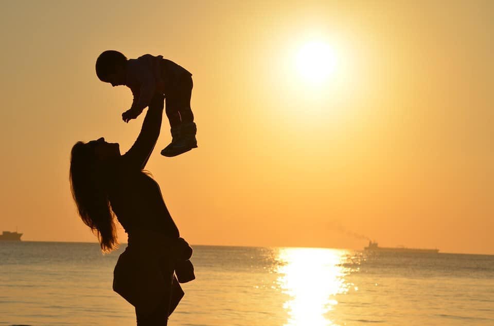 mother holding up her daughter